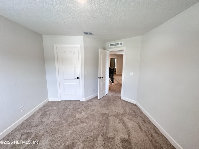 1116 Morgans Treasure Rd, Saint Augustine, FL 32084 - unfurnished bedroom with visible vents, a textured ceiling, carpet, and baseboards