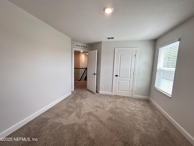 1116 Morgans Treasure Rd, Saint Augustine, FL 32084 - unfurnished bedroom with carpet floors, a textured ceiling, visible vents, and baseboards