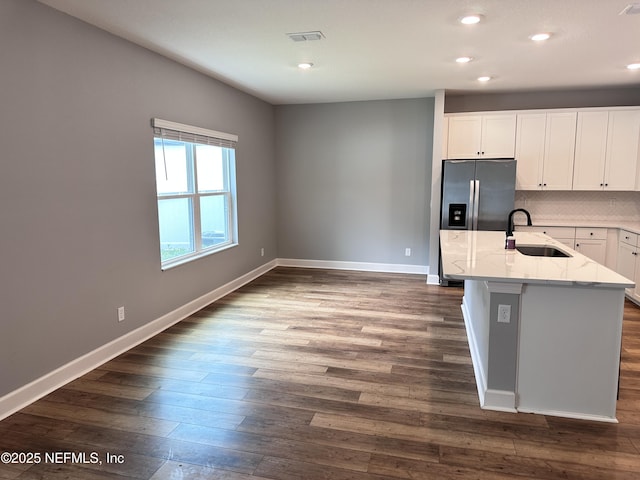 1116 Morgans Treasure Rd, Saint Augustine, FL 32084 - kitchen with dark wood-style flooring, light stone countertops, a sink, baseboards, and stainless steel fridge