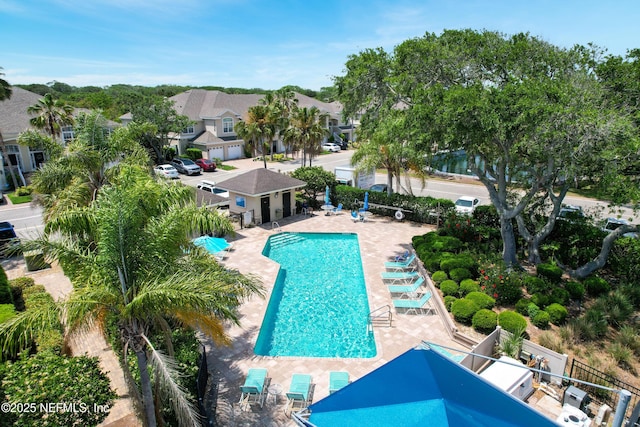 1207 Makarios Dr, Saint Augustine Beach, FL 32080 - community pool featuring a patio area, fence, and a residential view