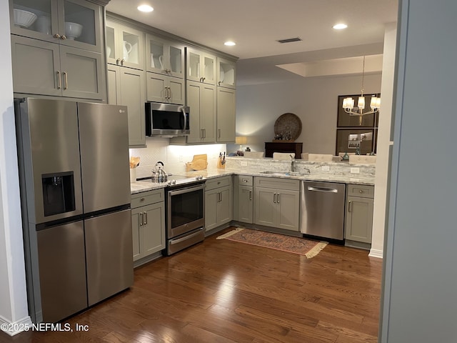 1207 Makarios Dr, Saint Augustine Beach, FL 32080 - kitchen featuring appliances with stainless steel finishes, a sink, dark wood finished floors, tasteful backsplash, and light stone countertops