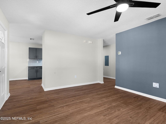 spare room with baseboards, dark wood-style floors, visible vents, a ceiling fan, and a textured ceiling