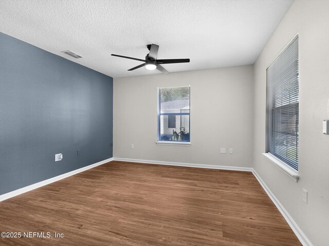 1615 Brook Forest Dr, Jacksonville, FL 32208 - empty room featuring ceiling fan, visible vents, baseboards, a textured ceiling, and wood finished floors