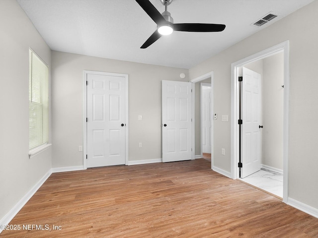unfurnished bedroom featuring light wood finished floors, a ceiling fan, visible vents, and baseboards