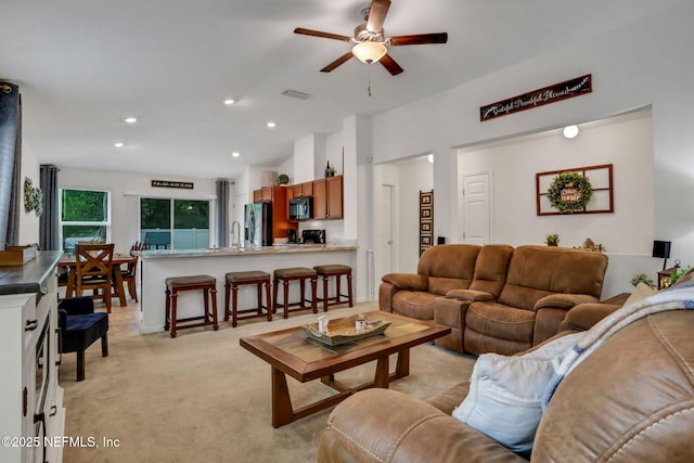 living area with visible vents, lofted ceiling, light colored carpet, recessed lighting, and a ceiling fan