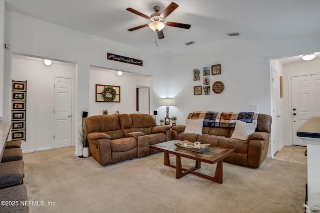living room with ceiling fan, visible vents, and light carpet