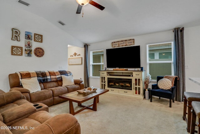 living room with vaulted ceiling, a ceiling fan, light colored carpet, and visible vents