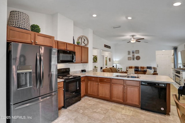 kitchen featuring a peninsula, open floor plan, ceiling fan, a sink, and black appliances