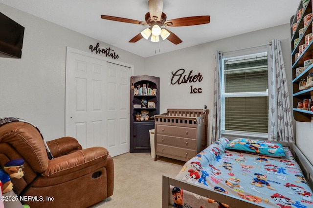 bedroom featuring a ceiling fan, light colored carpet, and a closet