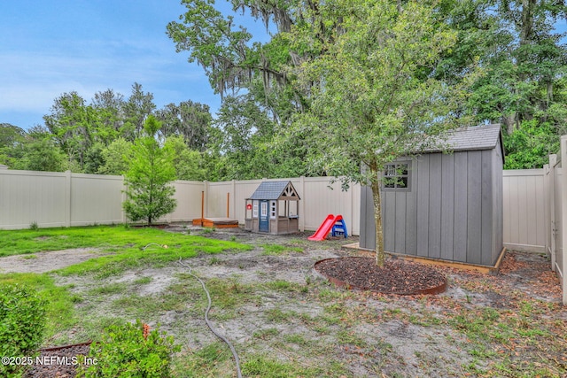 view of yard featuring an outdoor structure, a fenced backyard, and a shed