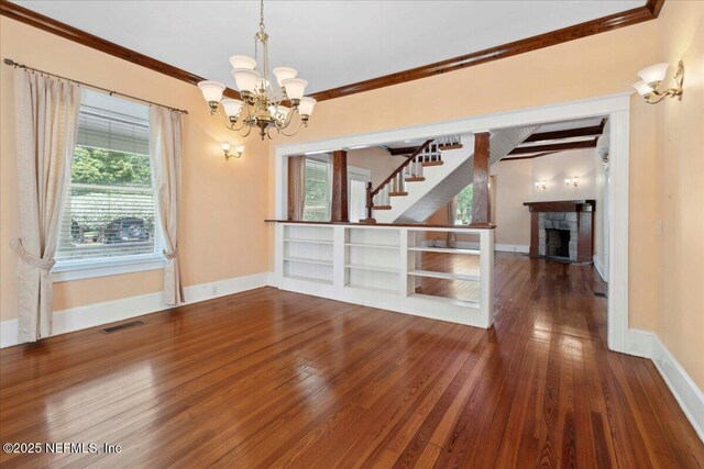 223 Rainey Ave, Saint Augustine, FL 32084 - spare room with a fireplace, a chandelier, hardwood / wood-style floors, baseboards, and visible vents
