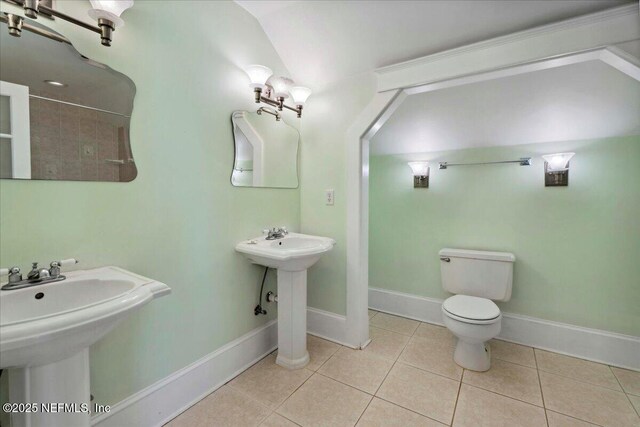 223 Rainey Ave, Saint Augustine, FL 32084 - full bath featuring tile patterned flooring, lofted ceiling, toilet, baseboards, and a sink