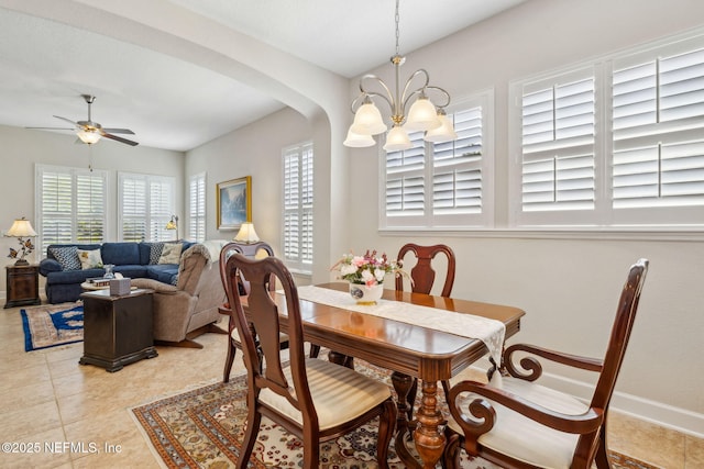74 Lone Eagle Way, Ponte Vedra, FL 32081 - dining room with arched walkways, baseboards, light tile patterned floors, and ceiling fan with notable chandelier
