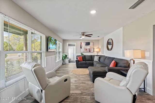 living room with visible vents, a ceiling fan, wainscoting, and dark wood-style floors