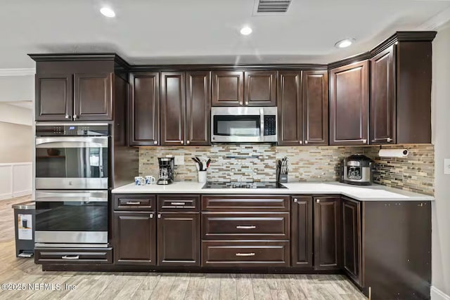 kitchen with visible vents, light countertops, appliances with stainless steel finishes, and dark brown cabinets