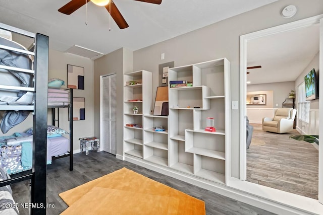 bedroom with a ceiling fan, baseboards, and wood finished floors