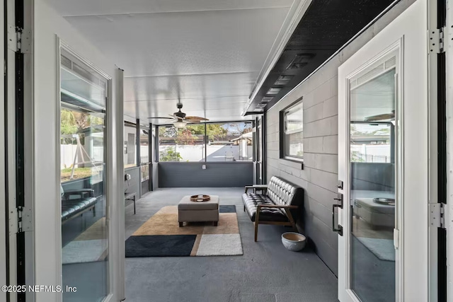 sunroom with a ceiling fan and an outdoor living space