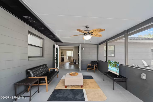 sunroom / solarium featuring a healthy amount of sunlight, ceiling fan, and an outdoor hangout area