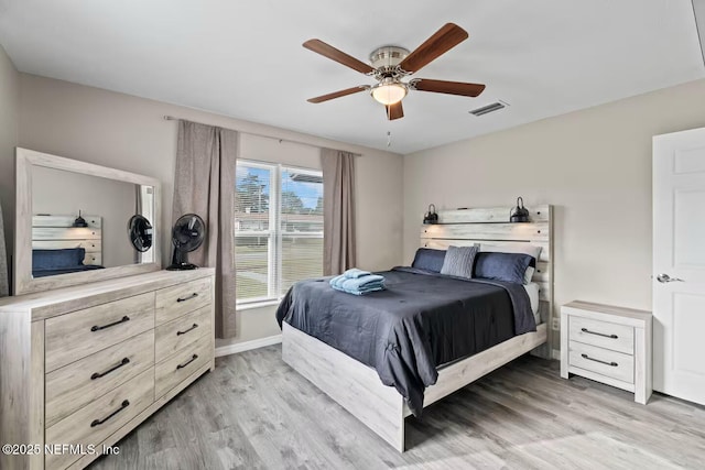 bedroom featuring baseboards, ceiling fan, light wood-style flooring, and visible vents