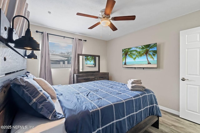 bedroom featuring baseboards, a ceiling fan, and wood finished floors