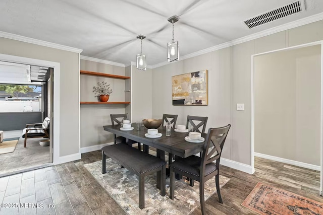 dining area featuring visible vents, baseboards, and wood finished floors