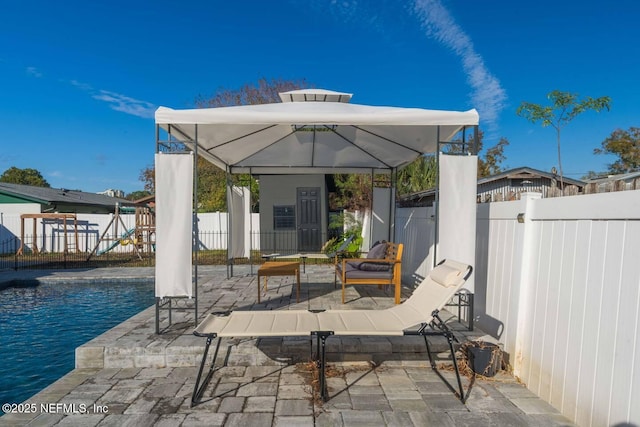 view of patio with a fenced backyard, a fenced in pool, and a gazebo