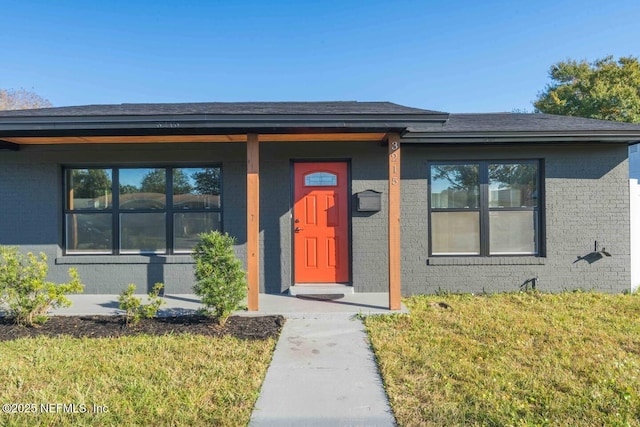 view of front of house with a front lawn and brick siding