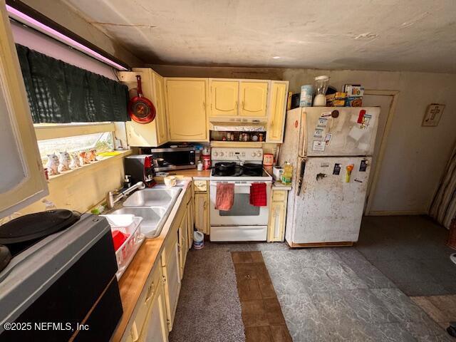 kitchen featuring light countertops, a sink, under cabinet range hood, and white appliances
