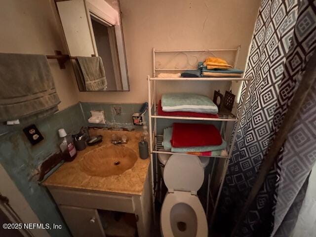 bathroom featuring toilet, a shower with curtain, and vanity