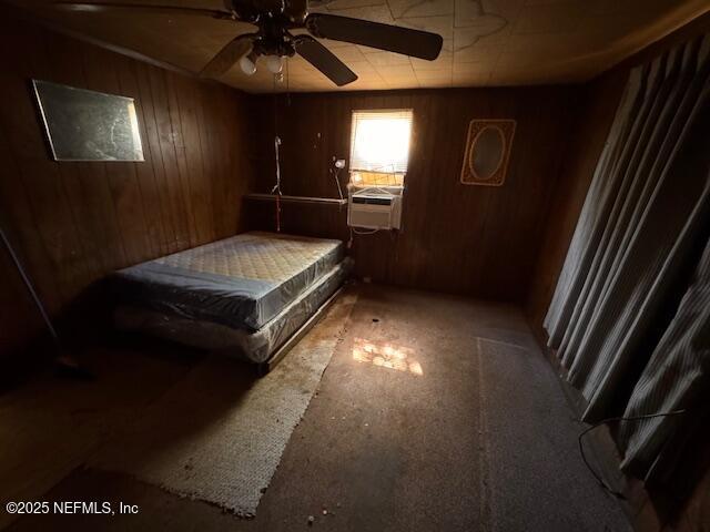 bedroom with wood walls, a ceiling fan, and cooling unit