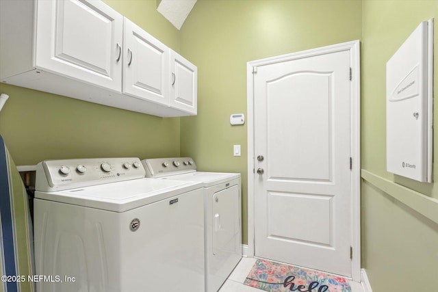 laundry room featuring light tile patterned flooring, separate washer and dryer, cabinet space, and baseboards