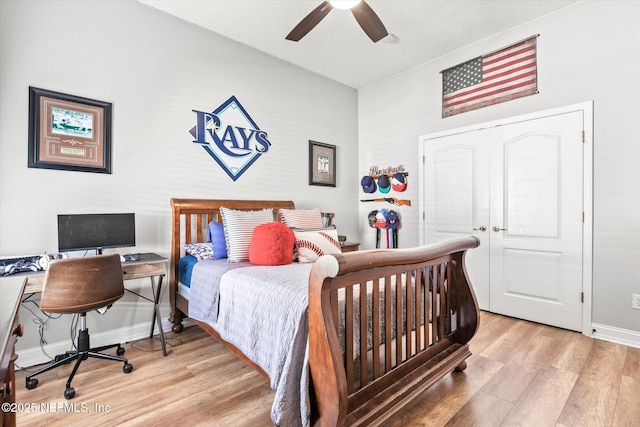 bedroom with light wood-style floors, a ceiling fan, and baseboards