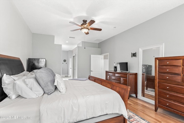 bedroom featuring visible vents, a ceiling fan, and light wood-style floors