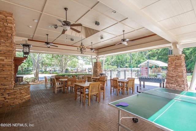 view of patio featuring outdoor dining area, ceiling fan, and fence