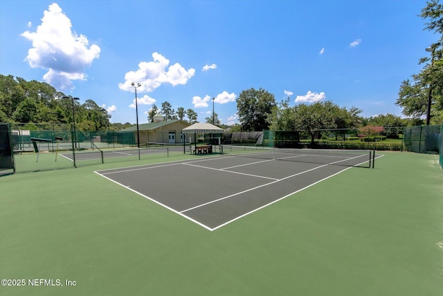 view of tennis court featuring fence and community basketball court