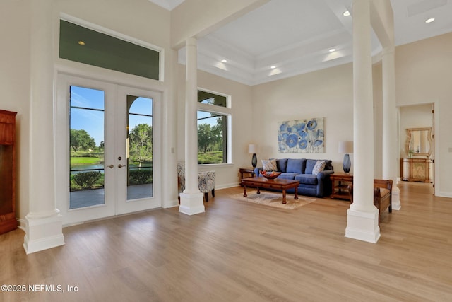 interior space featuring french doors, light wood-style flooring, and decorative columns