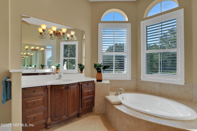 bathroom featuring tile patterned floors, a notable chandelier, a bath, and vanity