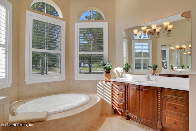 bathroom featuring a chandelier, a healthy amount of sunlight, and a garden tub