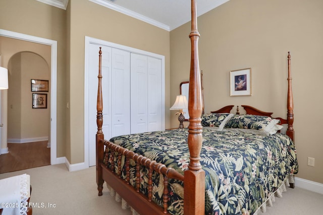 bedroom featuring crown molding, a closet, baseboards, and carpet flooring