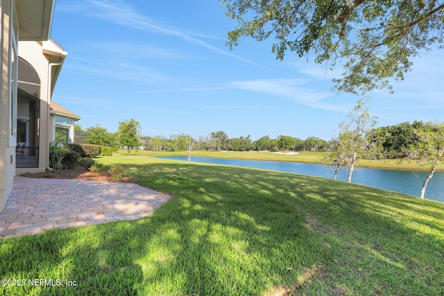 view of yard featuring a water view and a patio area
