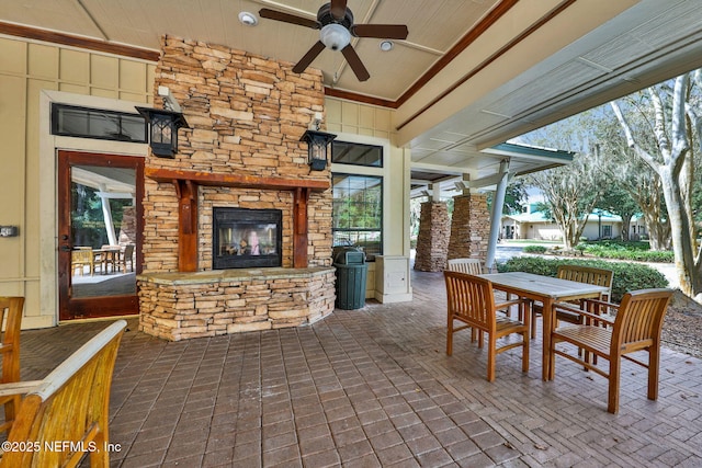 view of patio featuring an outdoor stone fireplace, ceiling fan, and outdoor dining area
