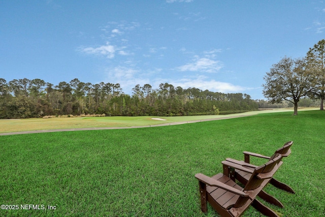 view of home's community with a lawn and view of golf course