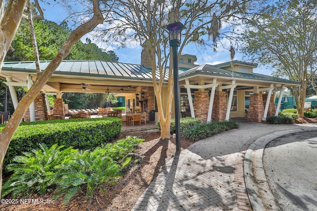 rear view of property with brick siding, an outdoor hangout area, ceiling fan, a standing seam roof, and metal roof
