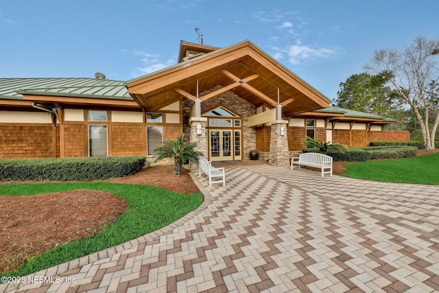 back of property featuring french doors, a standing seam roof, a patio area, and metal roof