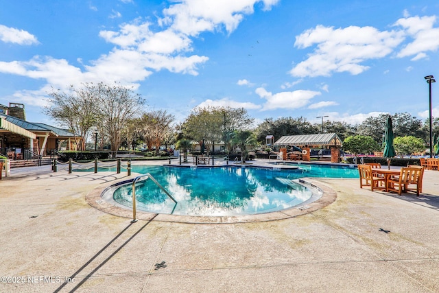 pool featuring a hot tub and a patio area