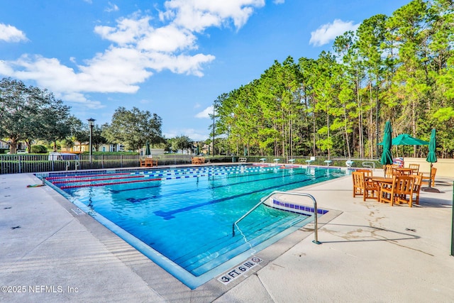 community pool featuring fence and a patio