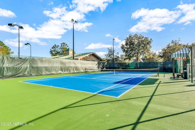 view of tennis court featuring fence