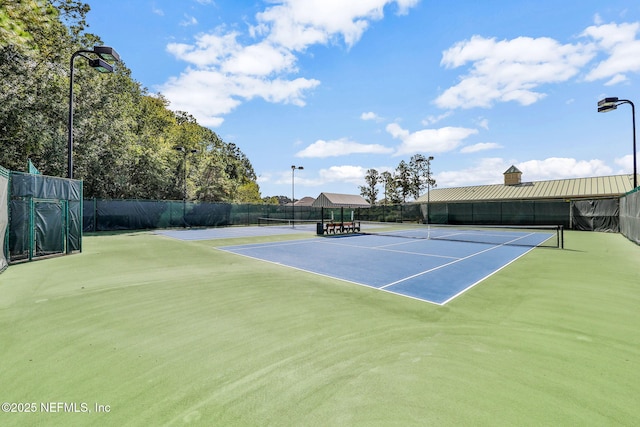 view of tennis court featuring fence