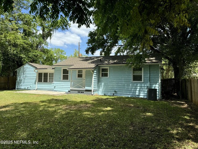 back of house featuring a lawn, cooling unit, and a fenced backyard