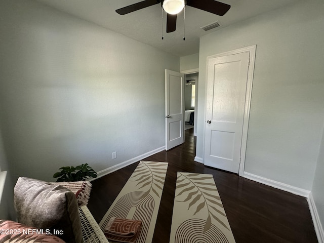 bedroom with dark wood-style floors, a ceiling fan, visible vents, and baseboards